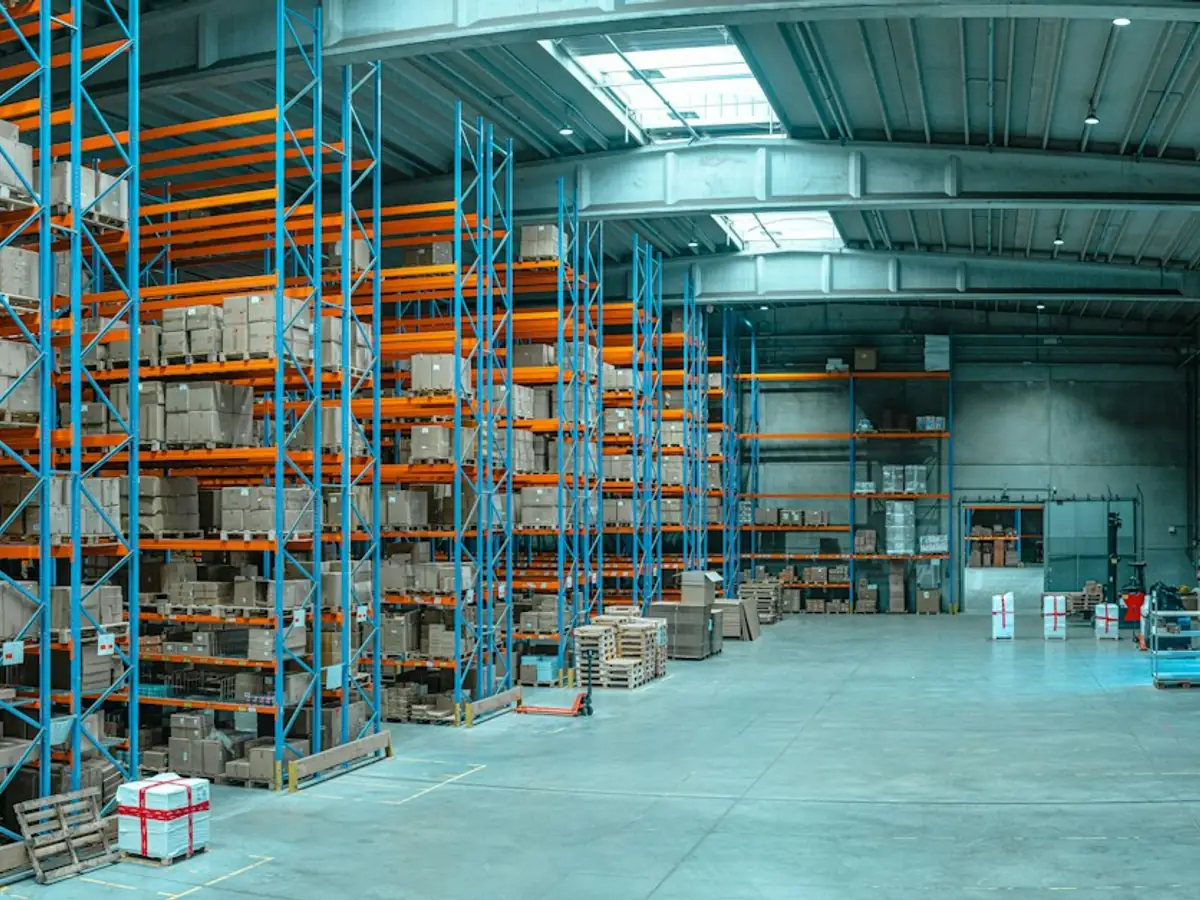 Almacén con estanterías altas y tarimas de producto
